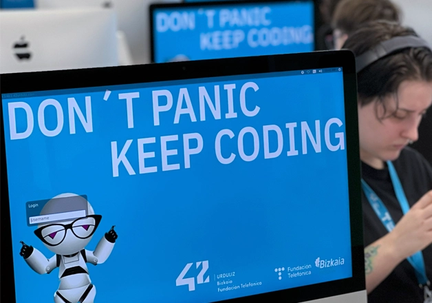42 Urduliz Bizkaiko ordenagailu baten pantaila-atzealdea, «Don't Panic, Keep Coding» dioena.