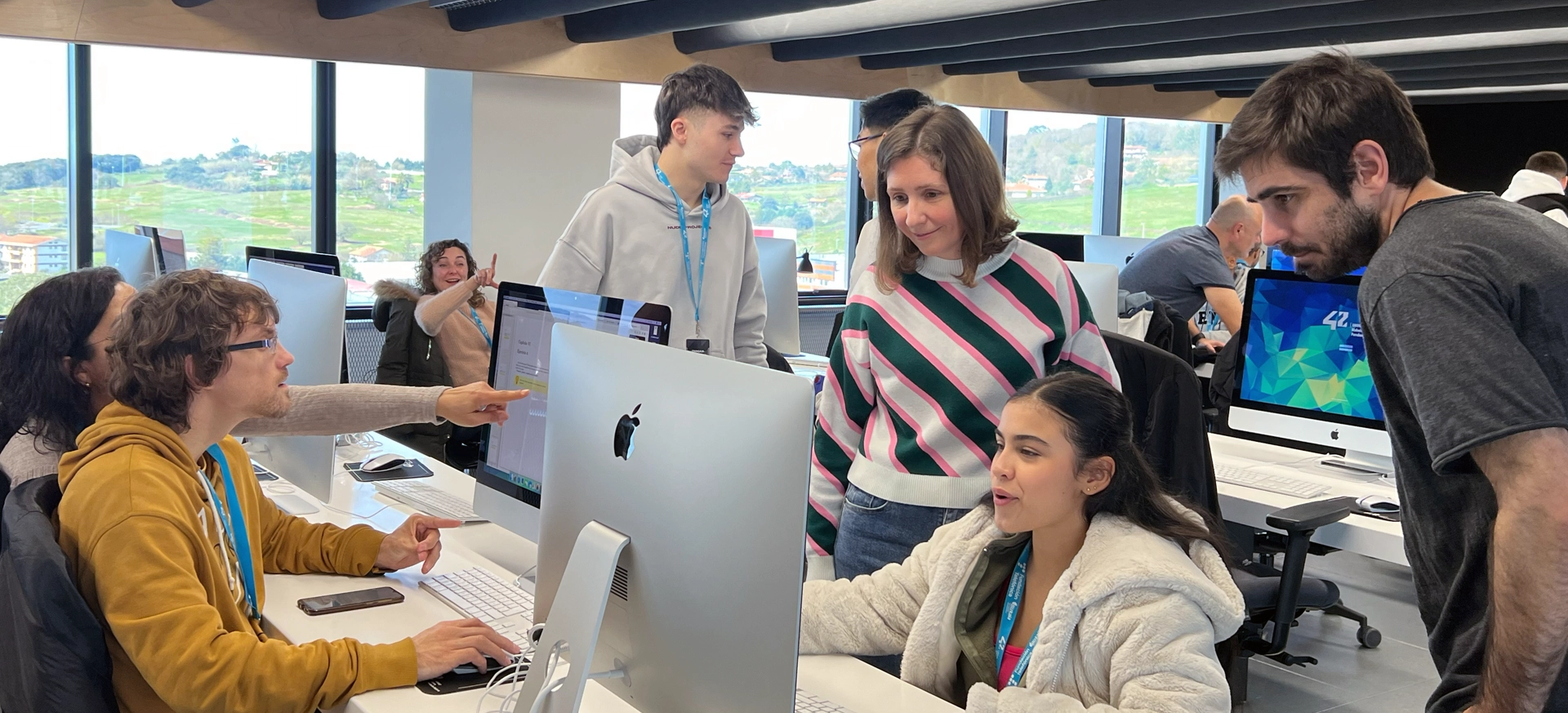 Grupo de personas delante de los ordenadores trabajando y aprendiendo en equipo en 42 Urduliz Bizkaia