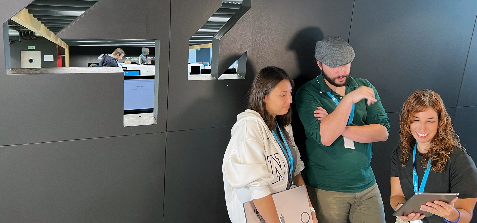 Three people looking at a tablet at 42 Urduliz Bizkaia