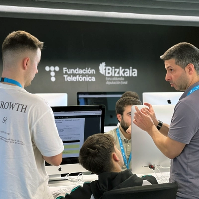 Digital Skills Lab-eko hiru parte hartzailek elkarrekin lan egiten daude ordenagailu baten inguruan